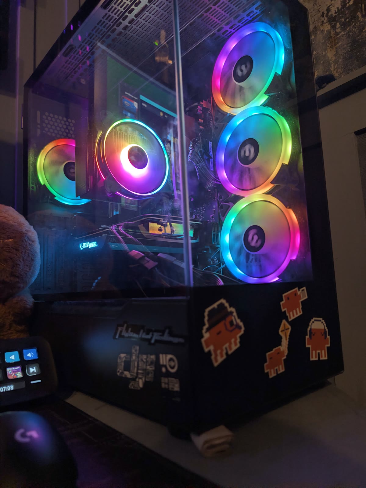 Close-up of the PC case with RGB fans and pixel-art Claude stickers